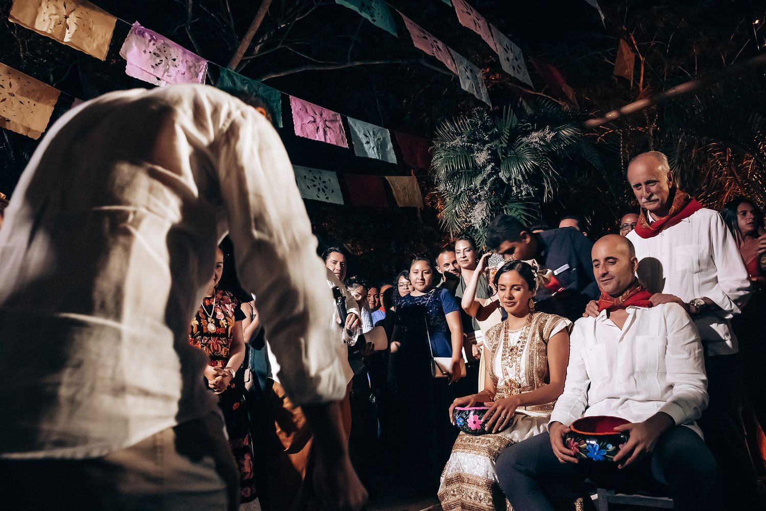 Dark reception venue with disco lights and dancing guests.