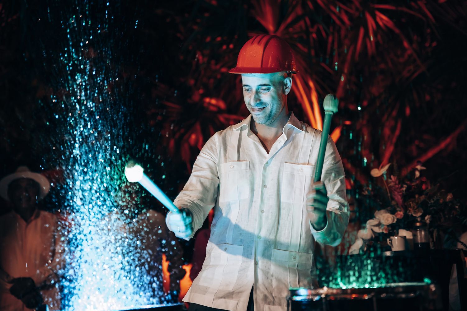Dance party scene with blue spotlight effects and guests in white clothing.