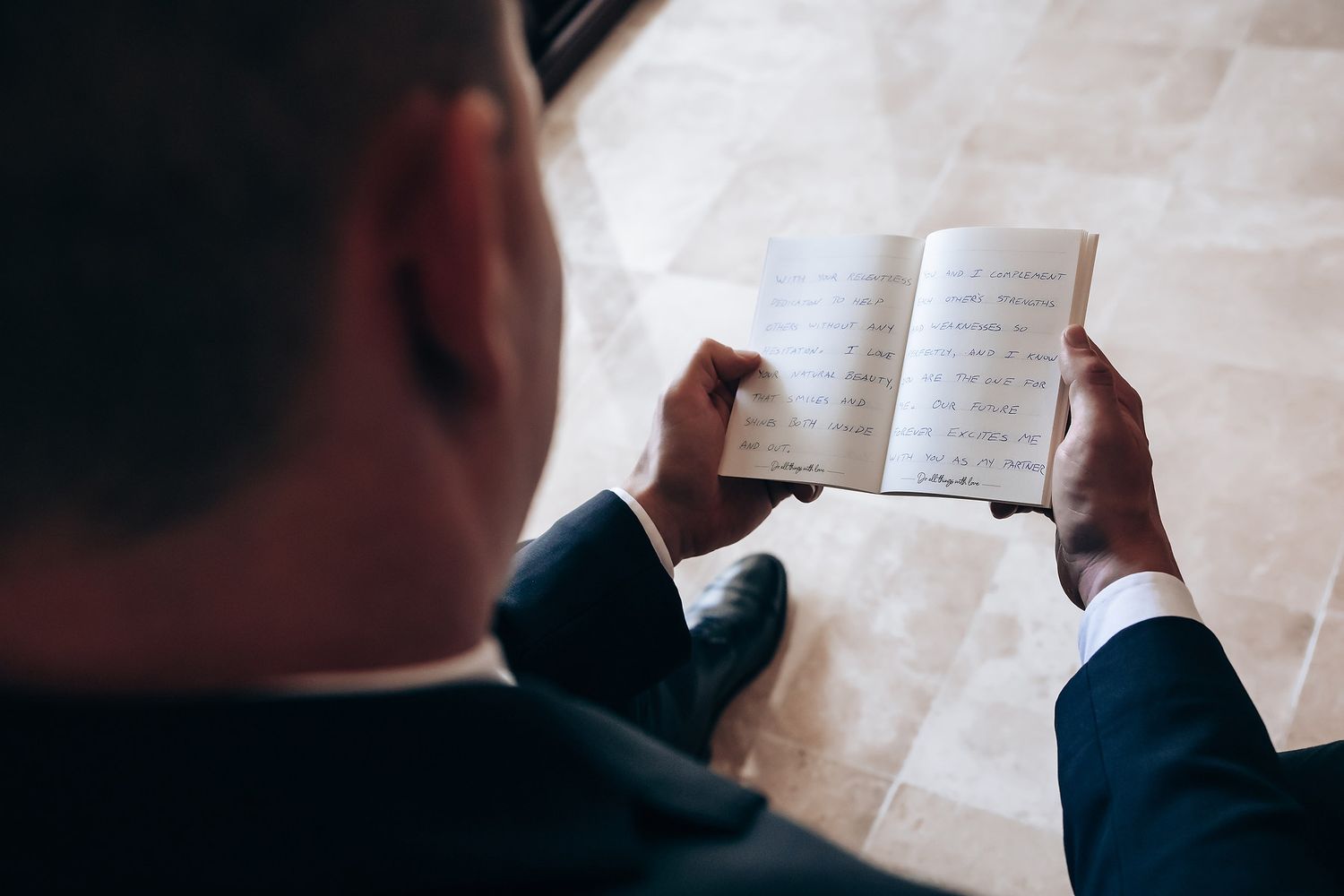 Person reading from paper during wedding ceremony preparations.