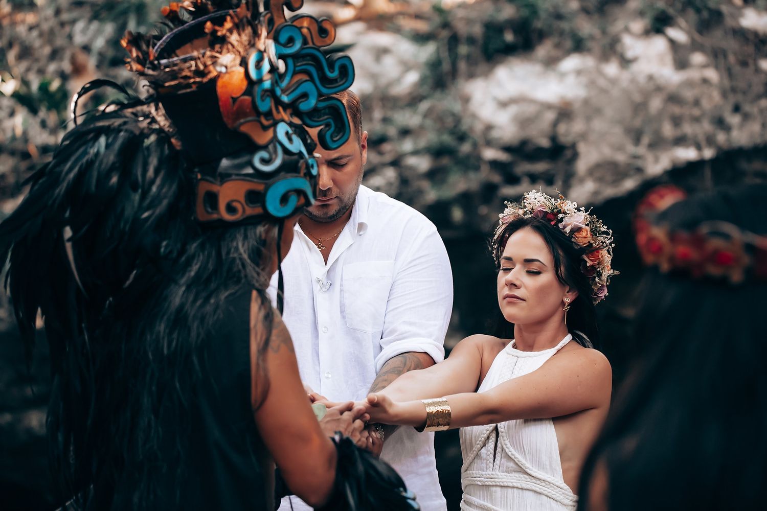 Couple embracing during a romantic outdoor wedding ceremony surrounded by trees.
