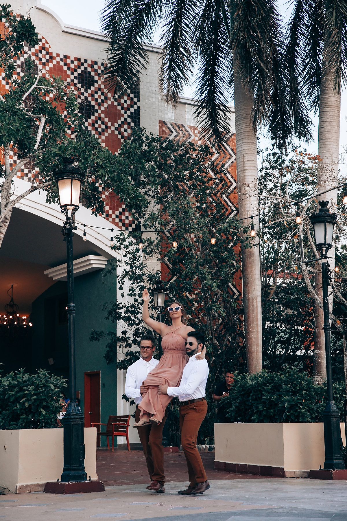 Palm trees and decorative lattice create a tropical ambiance at an outdoor venue.