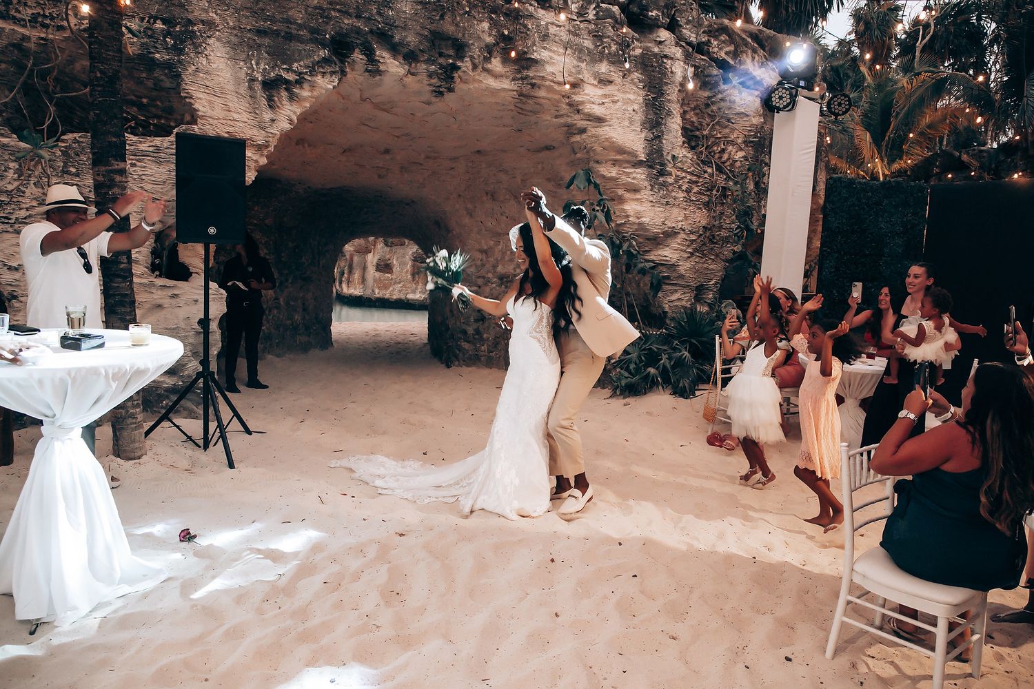 Wedding reception dance party on the beach with guests celebrating.