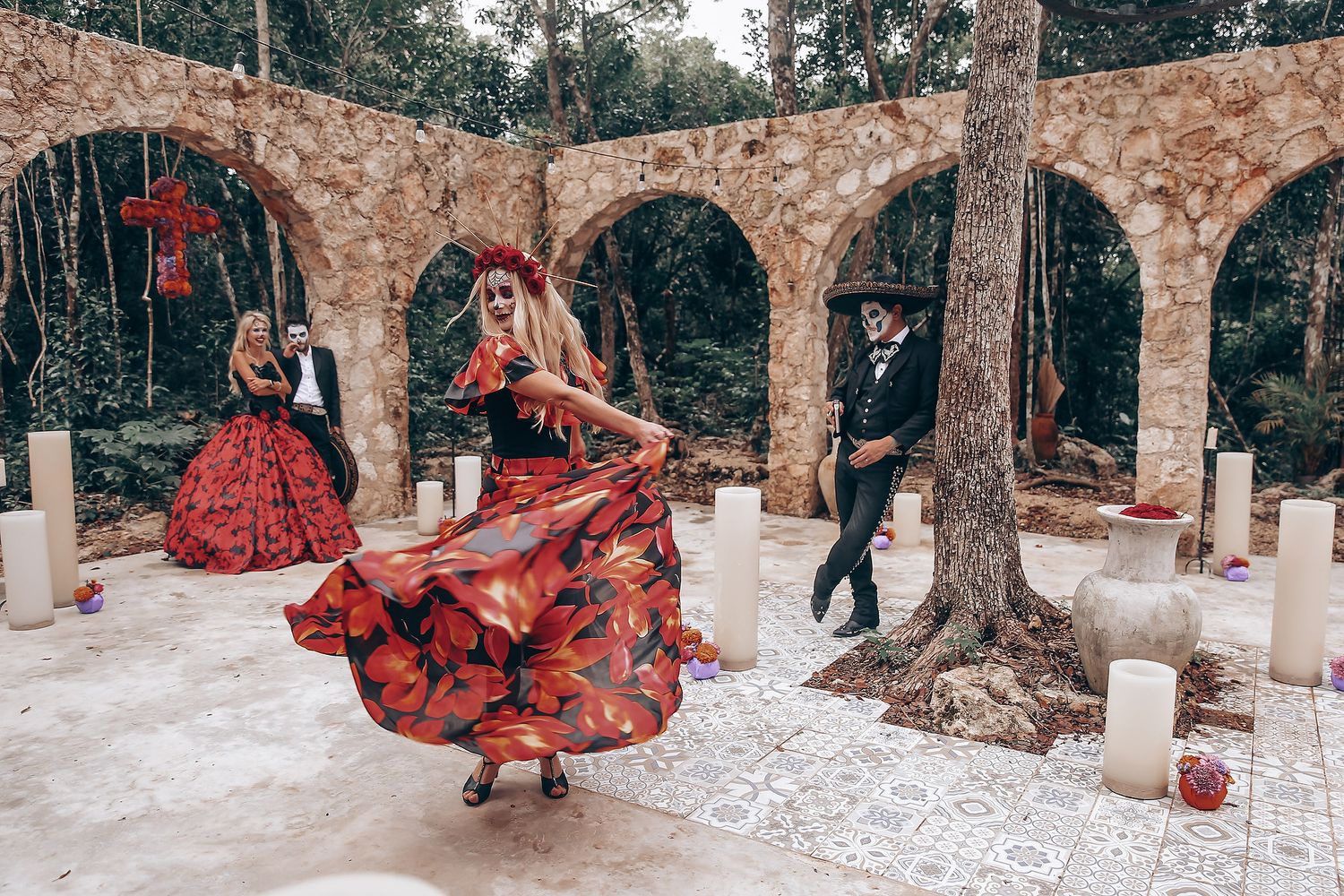 A red flamenco dress twirls dramatically among trees and candles in an outdoor setting.