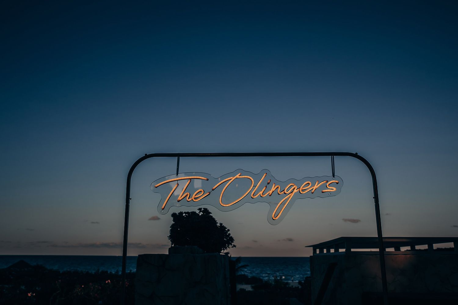 A neon sign that reads 'The Clingers' against a dark sky.