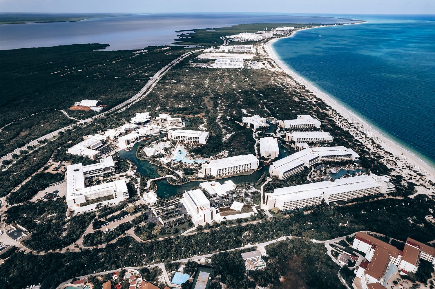 Aerial view of a coastal town with a long beach and clear blue waters.