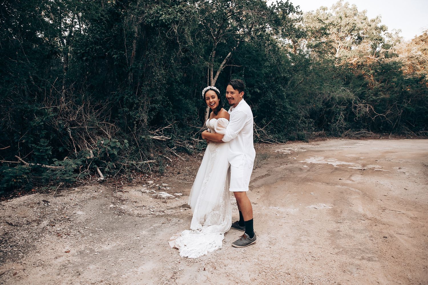A couple walks together through a wooded path in a romantic outdoor engagement photo session.