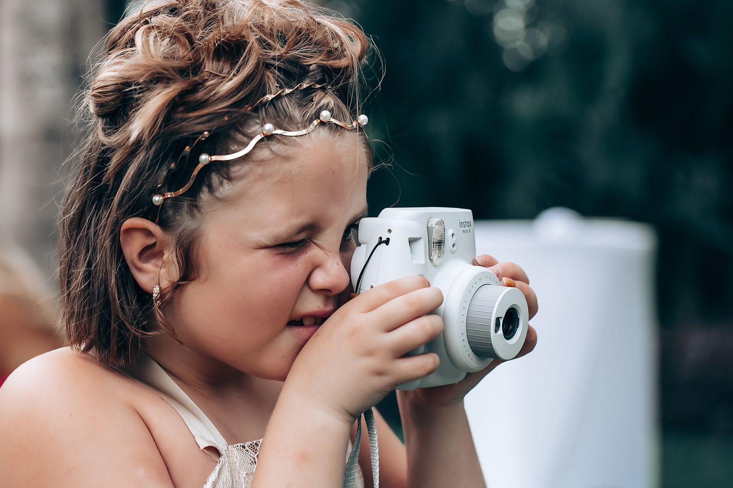Close-up shot of photographer capturing moments at outdoor wedding.