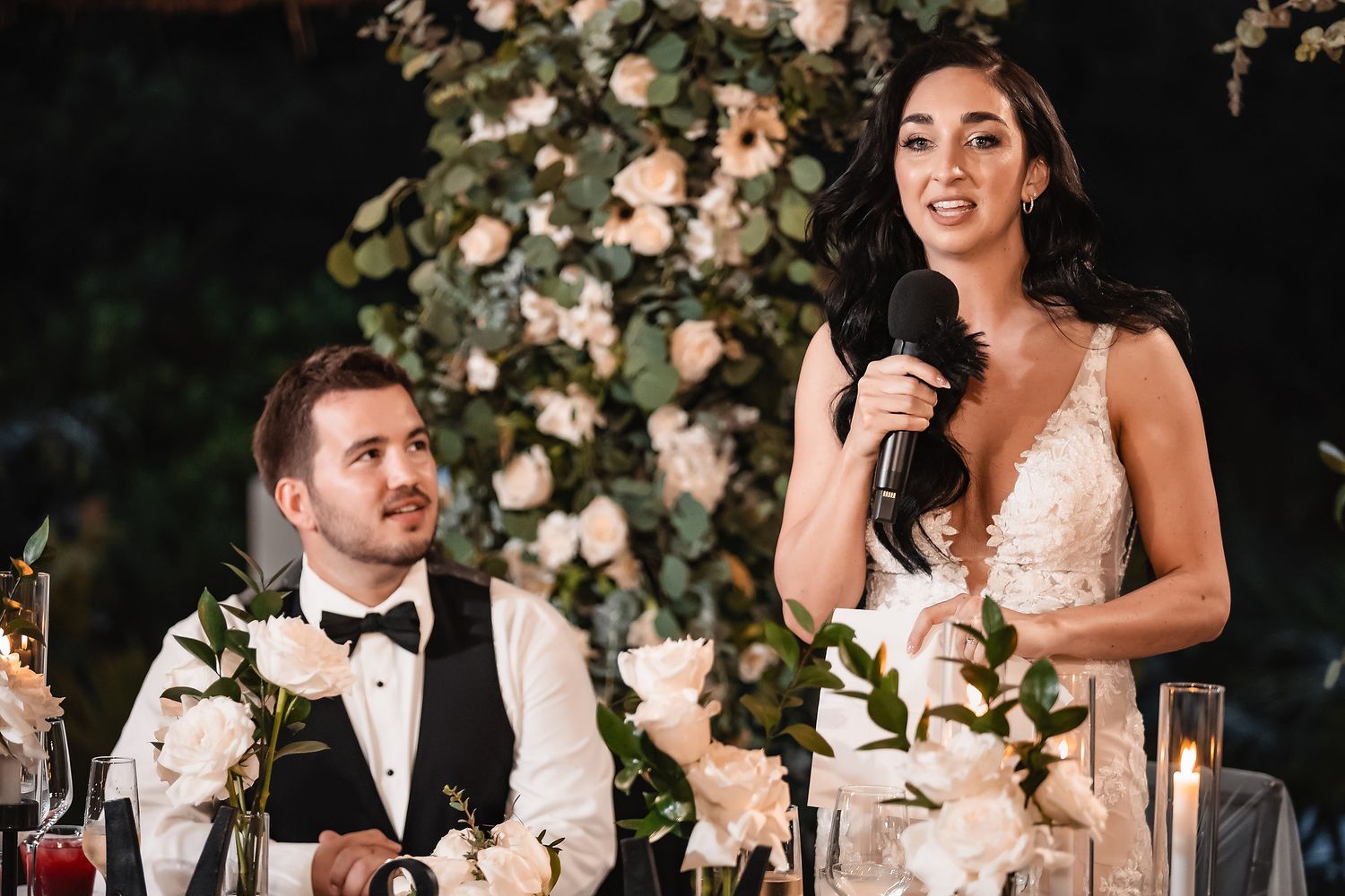 Wedding reception toasts with floral arrangements and candlelight.