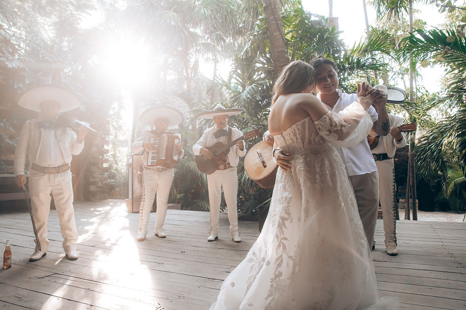 A series of sunlit wedding photos showing a couple dancing and embracing on a palm tree lined patio.