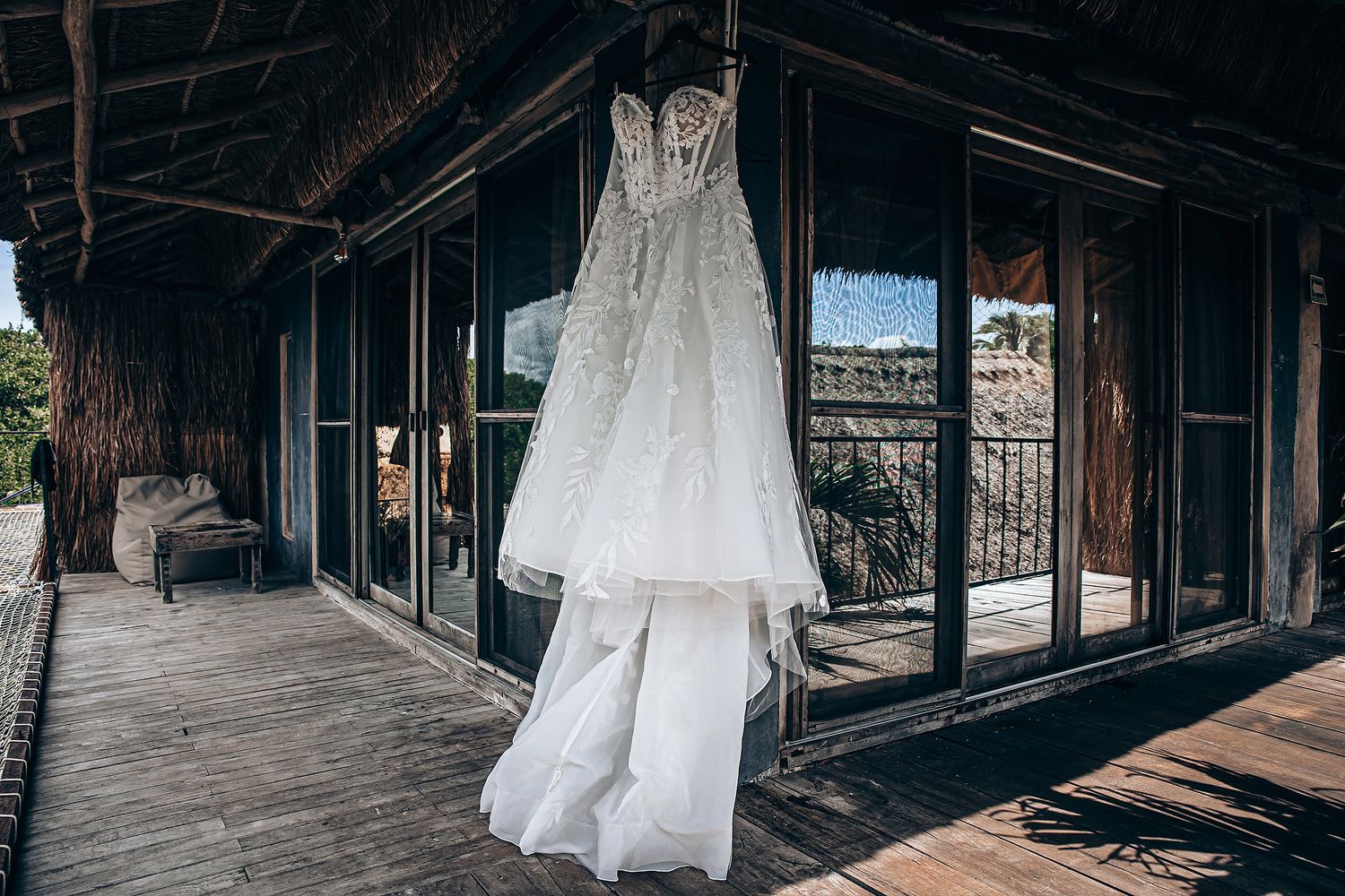 White wedding dresses hang elegantly in a rustic wooden barn venue creating a romantic bridal preparation scene.