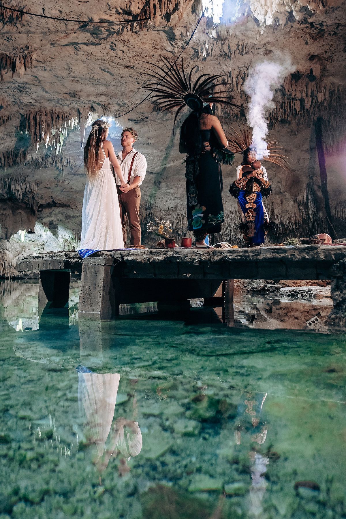 Cave wedding photography session with crystal clear water reflections and natural cave formations.