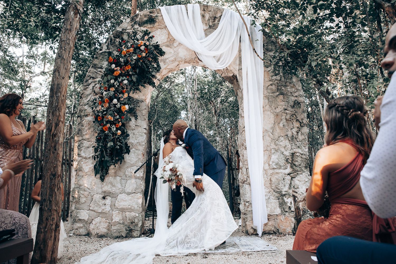 Bride and groom walking through Arcadia Tulum arches wedding venue