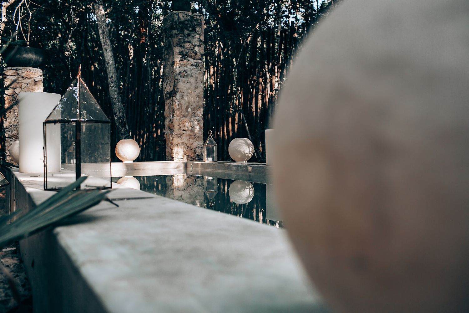 Minimalist pool area with decorative spheres and stone elements reflects modern architectural design.