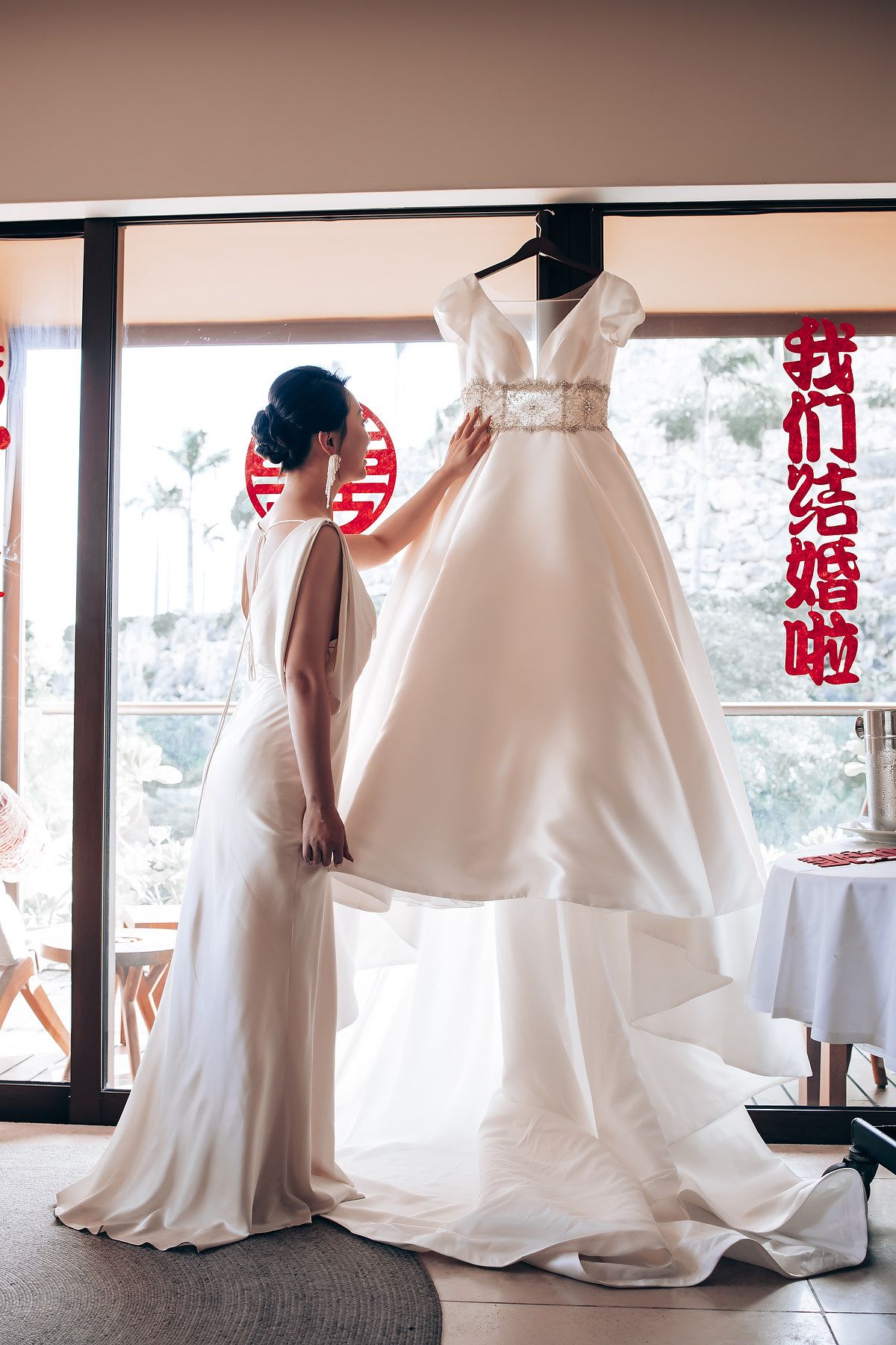 White wedding gowns arranged in a room with traditional Chinese happiness symbols.