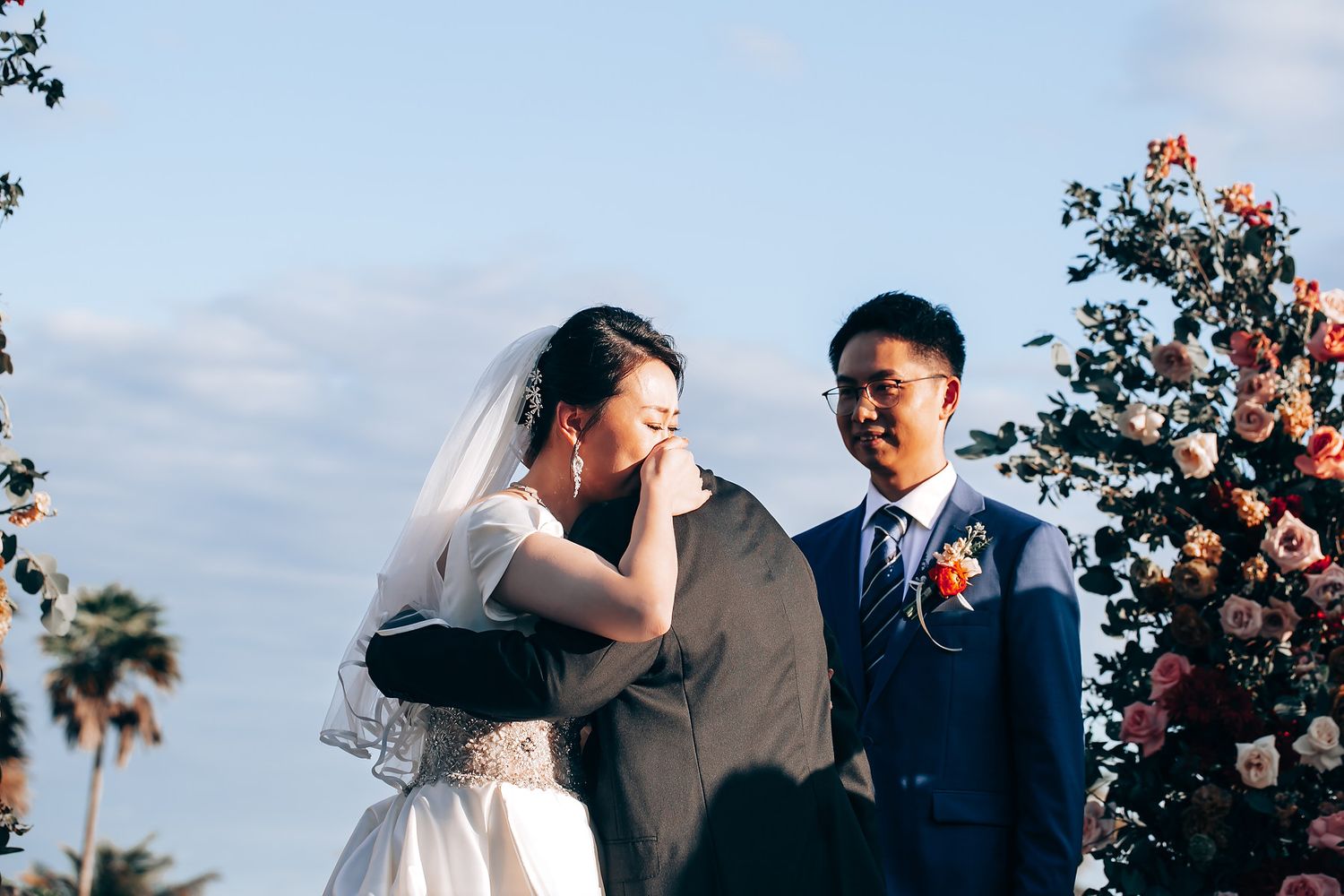 Outdoor wedding ceremony setup with floral arrangements and natural lighting.