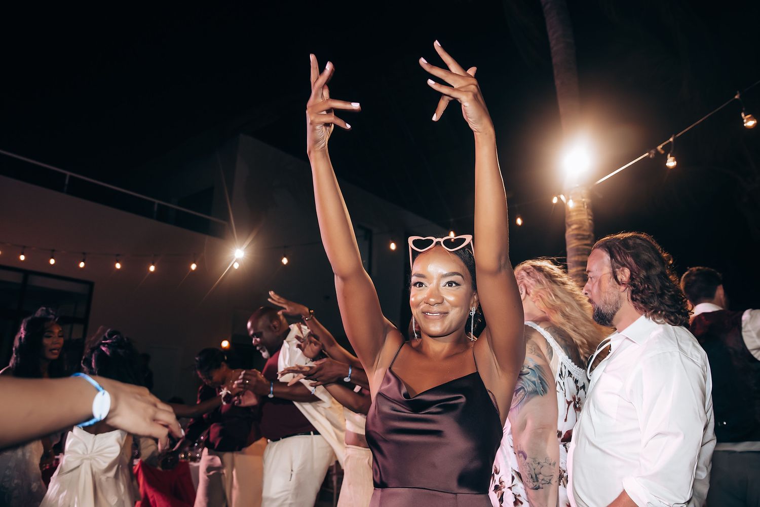People dancing and celebrating at a lively nightclub party with bright lights and energetic atmosphere.