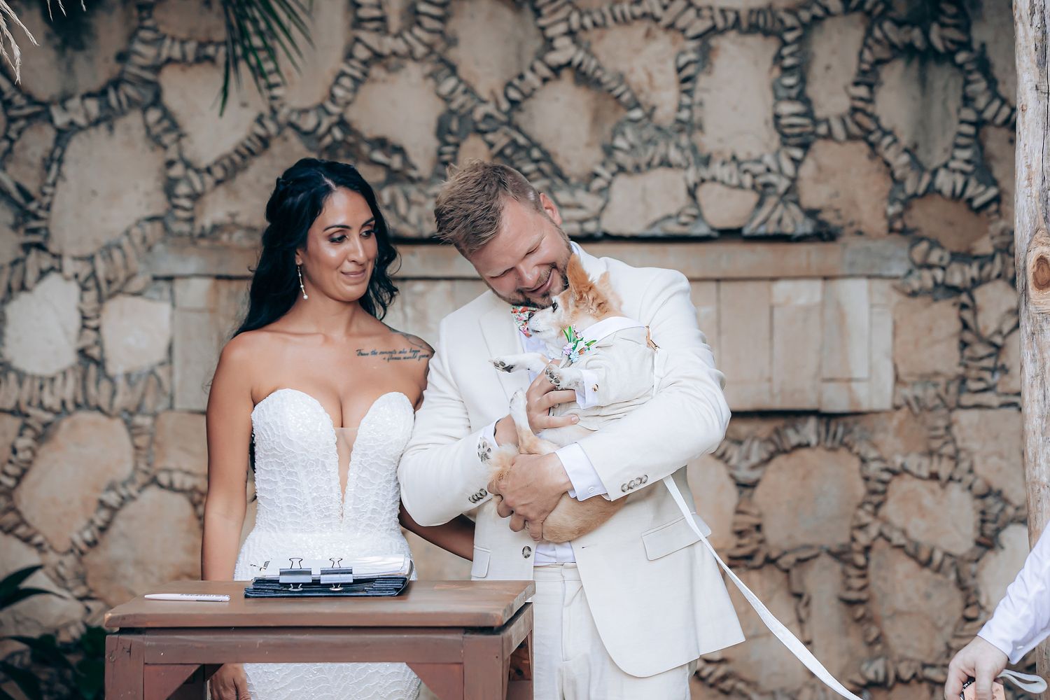 Wedding couple sharing an intimate moment in a stone-walled garden setting.
