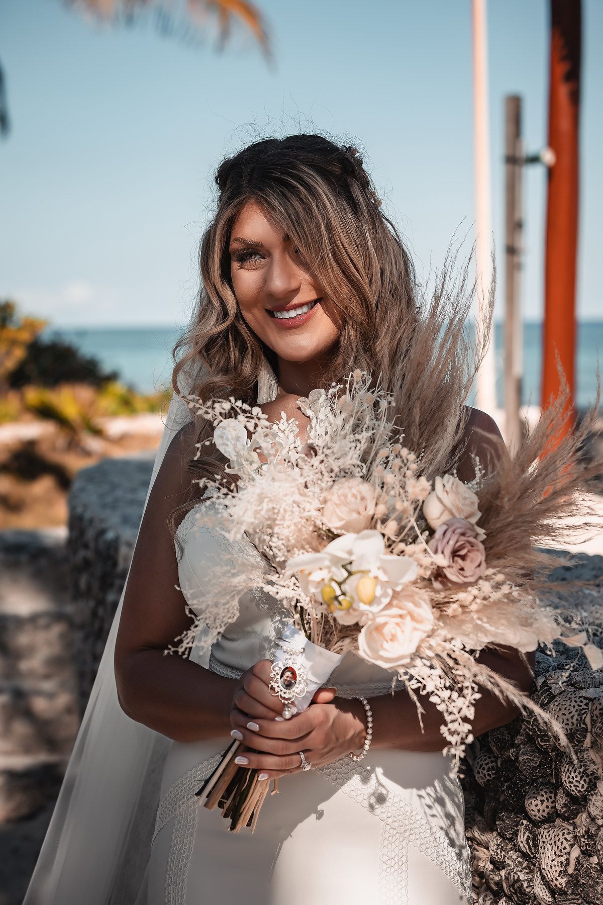 Close-up of a beautiful dried flower and rose wedding bouquet in soft peach tones.