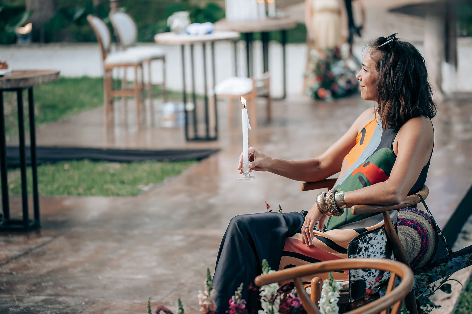 People sitting on a porch enjoy drinks and conversation on a summer evening.