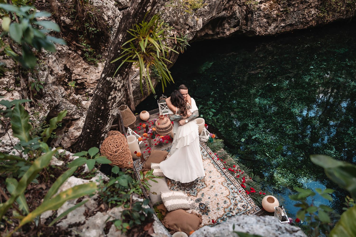 Aerial view of decorated platform over turquoise cenote waters.