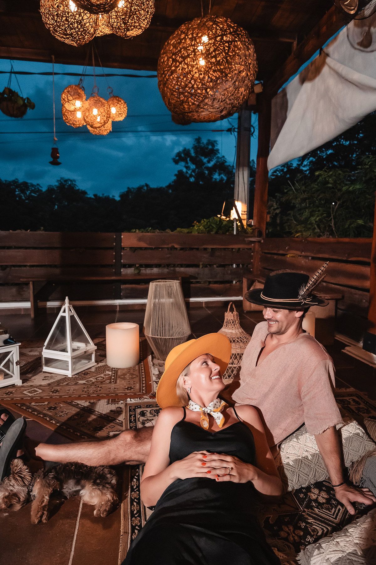 Cozy lounge area under wooden pergola with spherical pendant lights creating romantic ambiance.