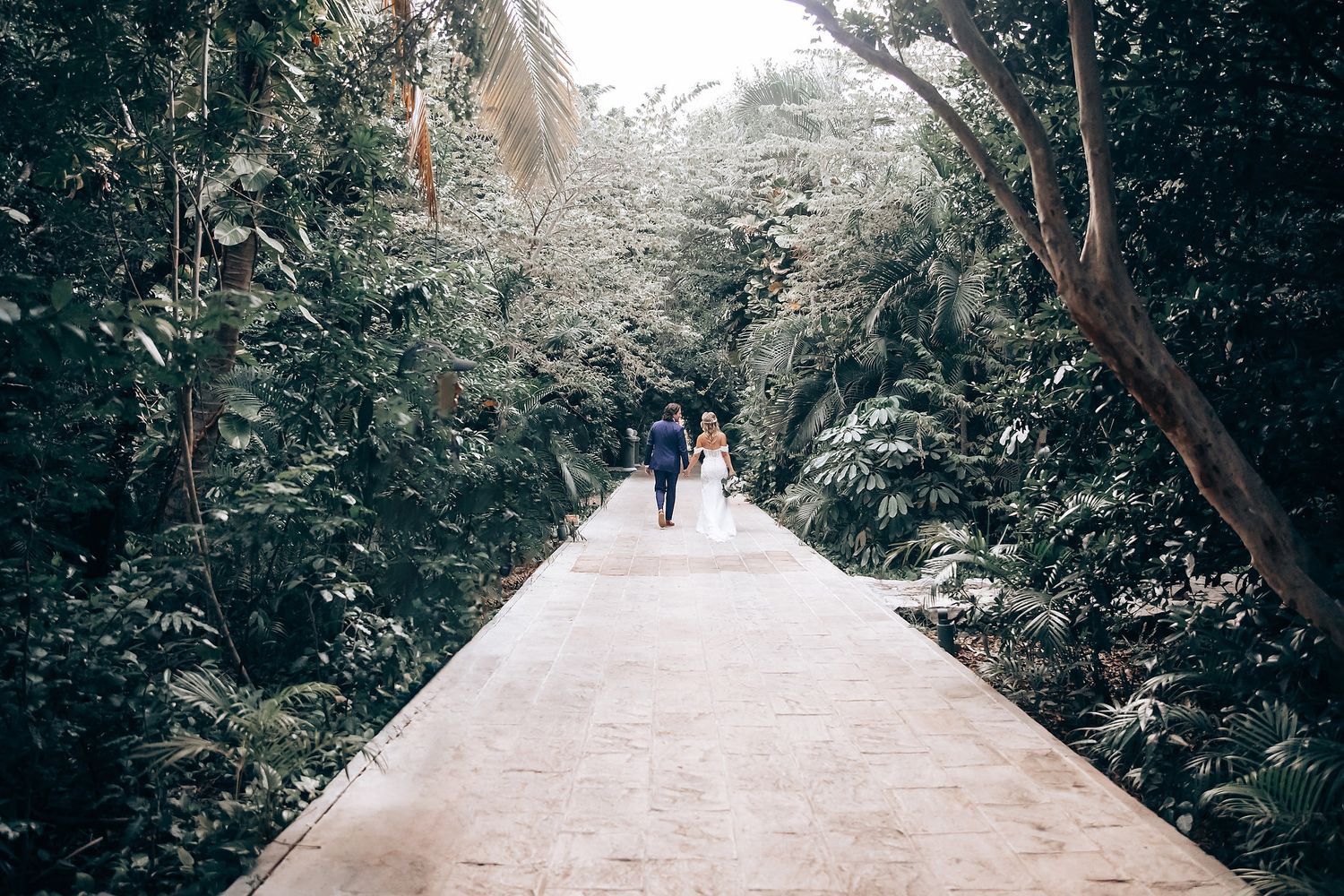 Tree-lined pathway through a lush garden setting perfect for wedding photography.