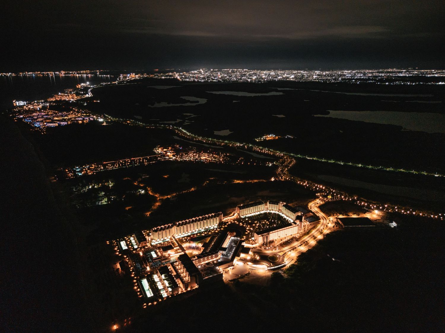 Aerial nighttime view of illuminated buildings and streets creating a stunning cityscape.
