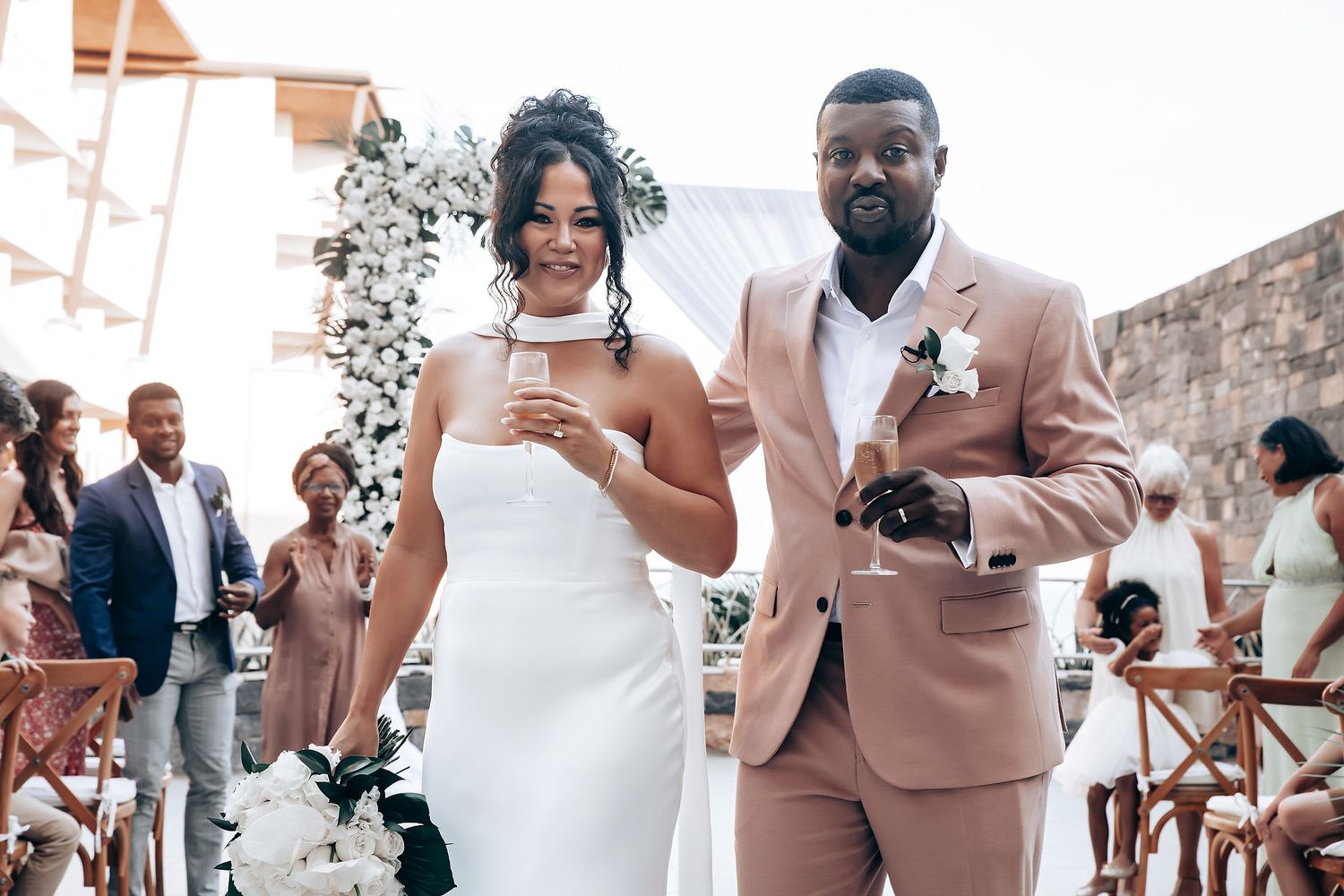 Wedding celebration candid moments captured at an outdoor venue with elegant decor and stone backdrop.
