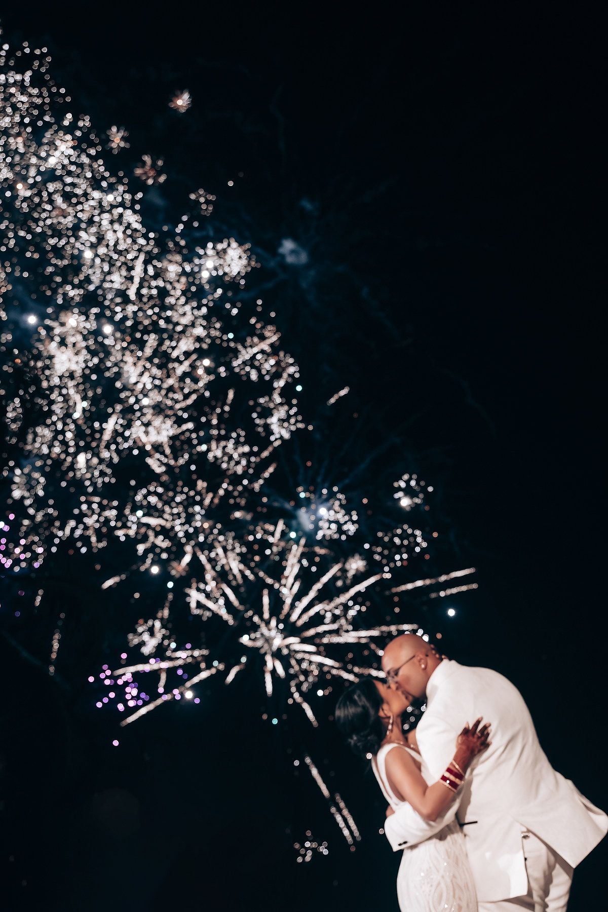 Fireworks light up the night sky during a celebration on the beach.