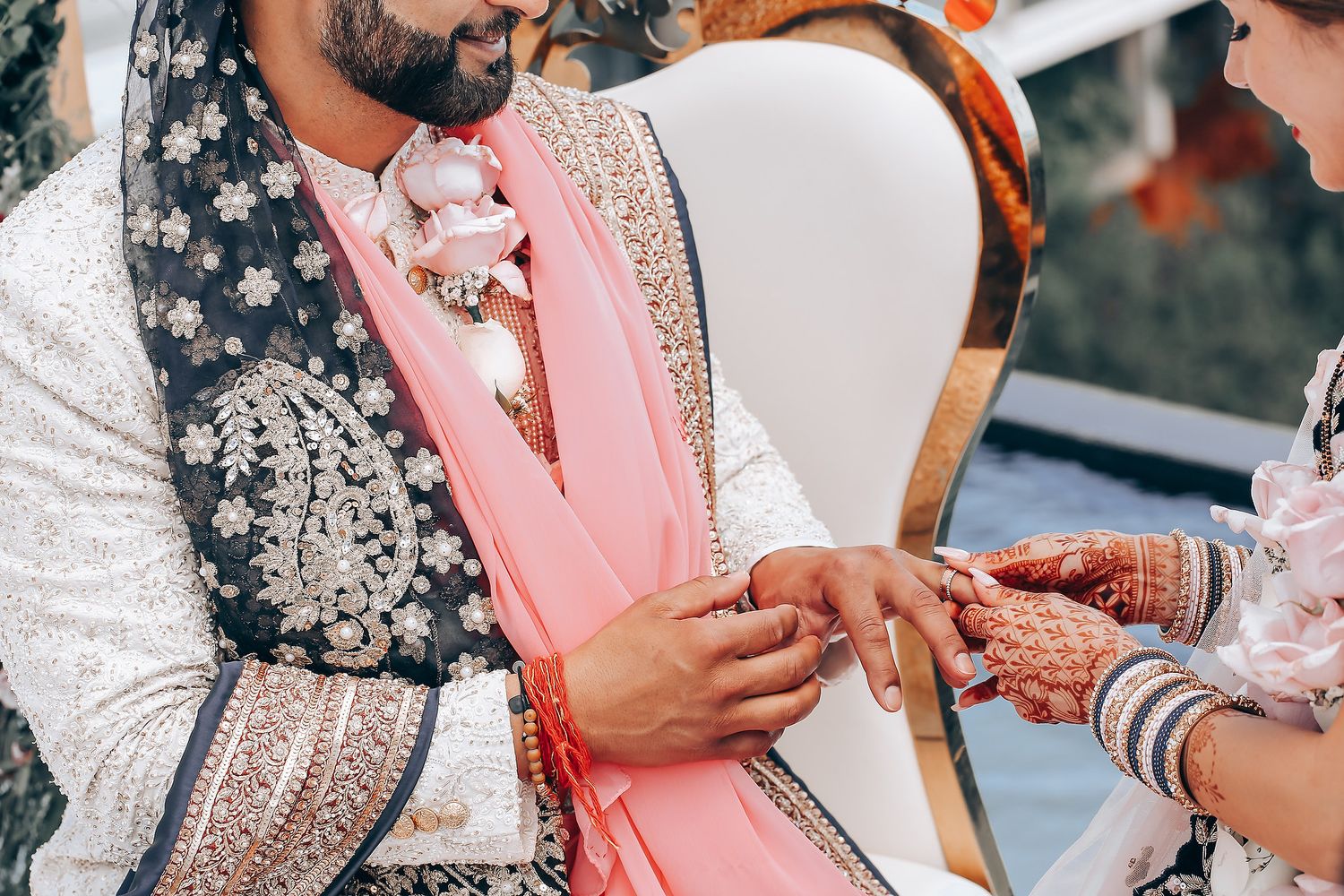 A couple in traditional Indian wedding attire sharing an intimate moment during their ceremony celebration.