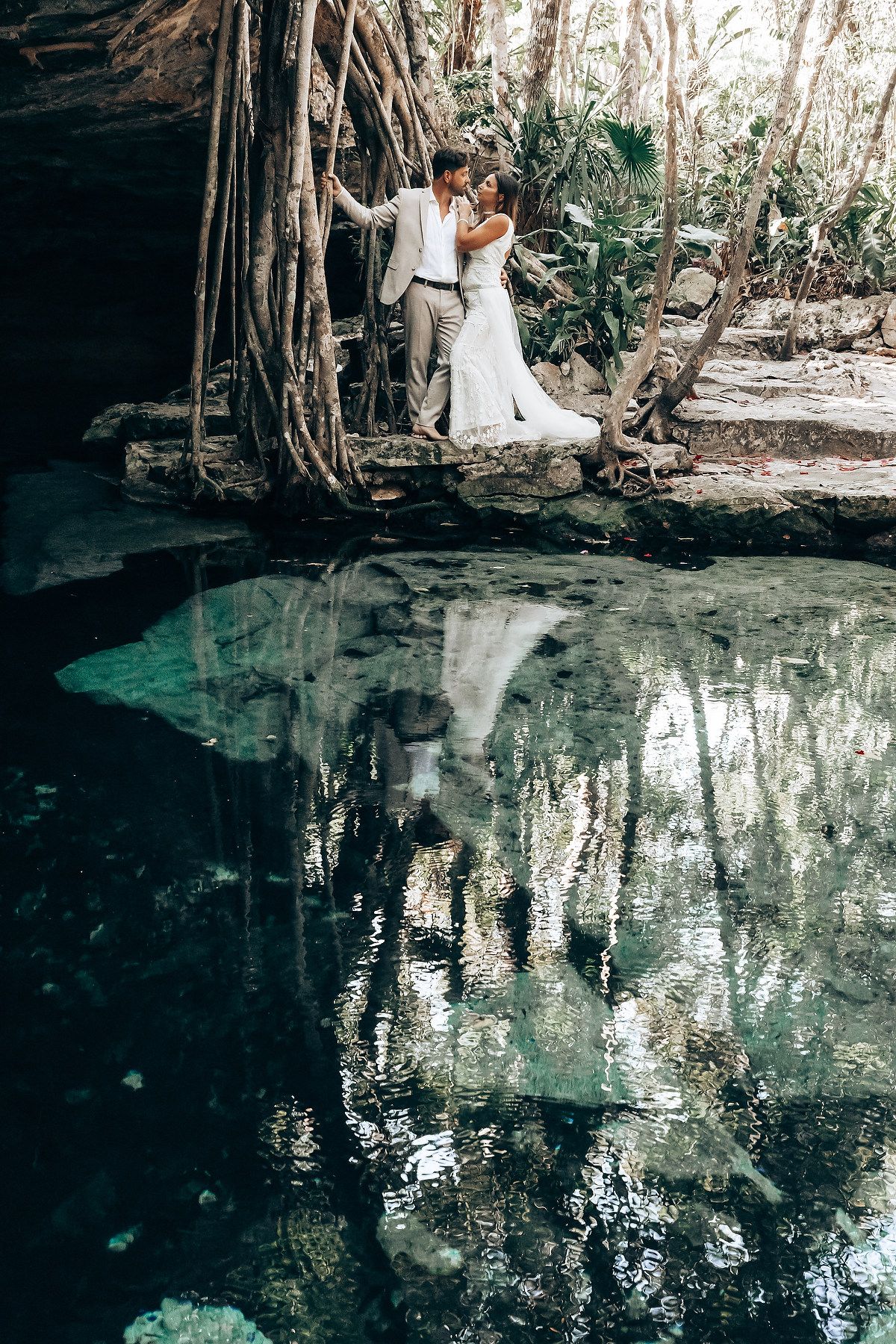 Mystical cenote reflection captures ceremony participants among ancient trees in Mexico.