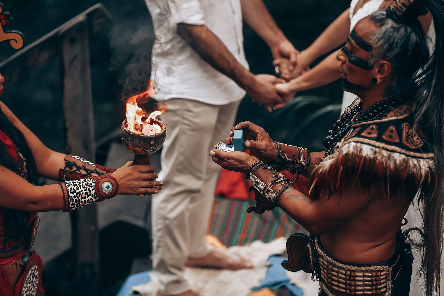 Traditional indigenous ceremony with fire and ritual blessings being performed in natural setting.