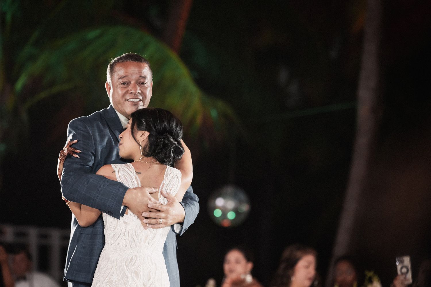 Bride and groom share an emotional first dance embrace at their tropical outdoor wedding reception.