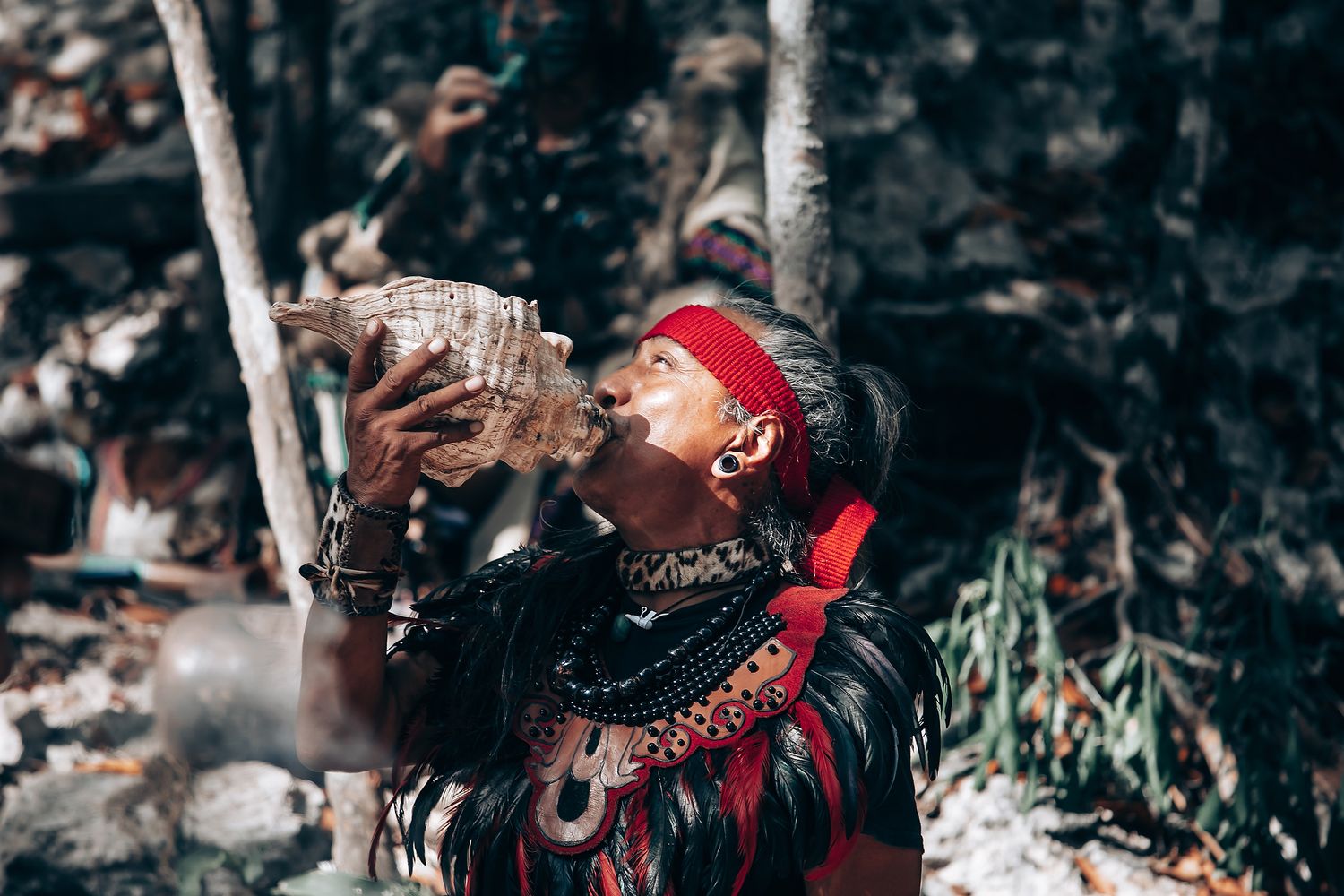 Traditional Mayan spiritual ceremony with smoke and ritual elements in natural setting.
