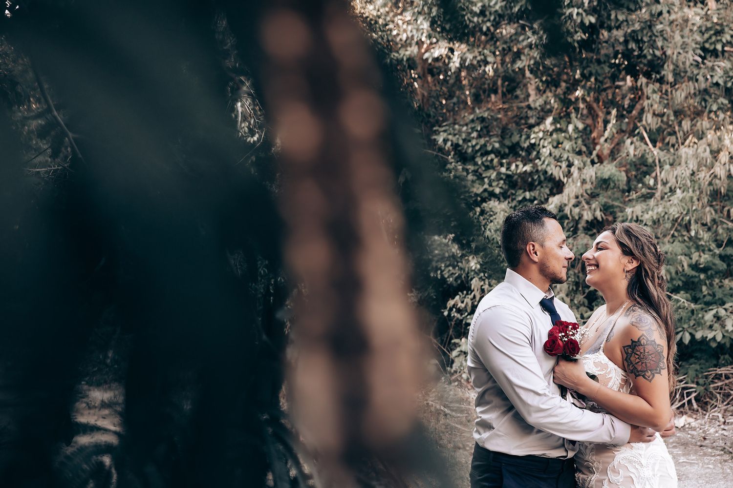 Intimate wedding couple moment captured during sunset in a natural outdoor setting.