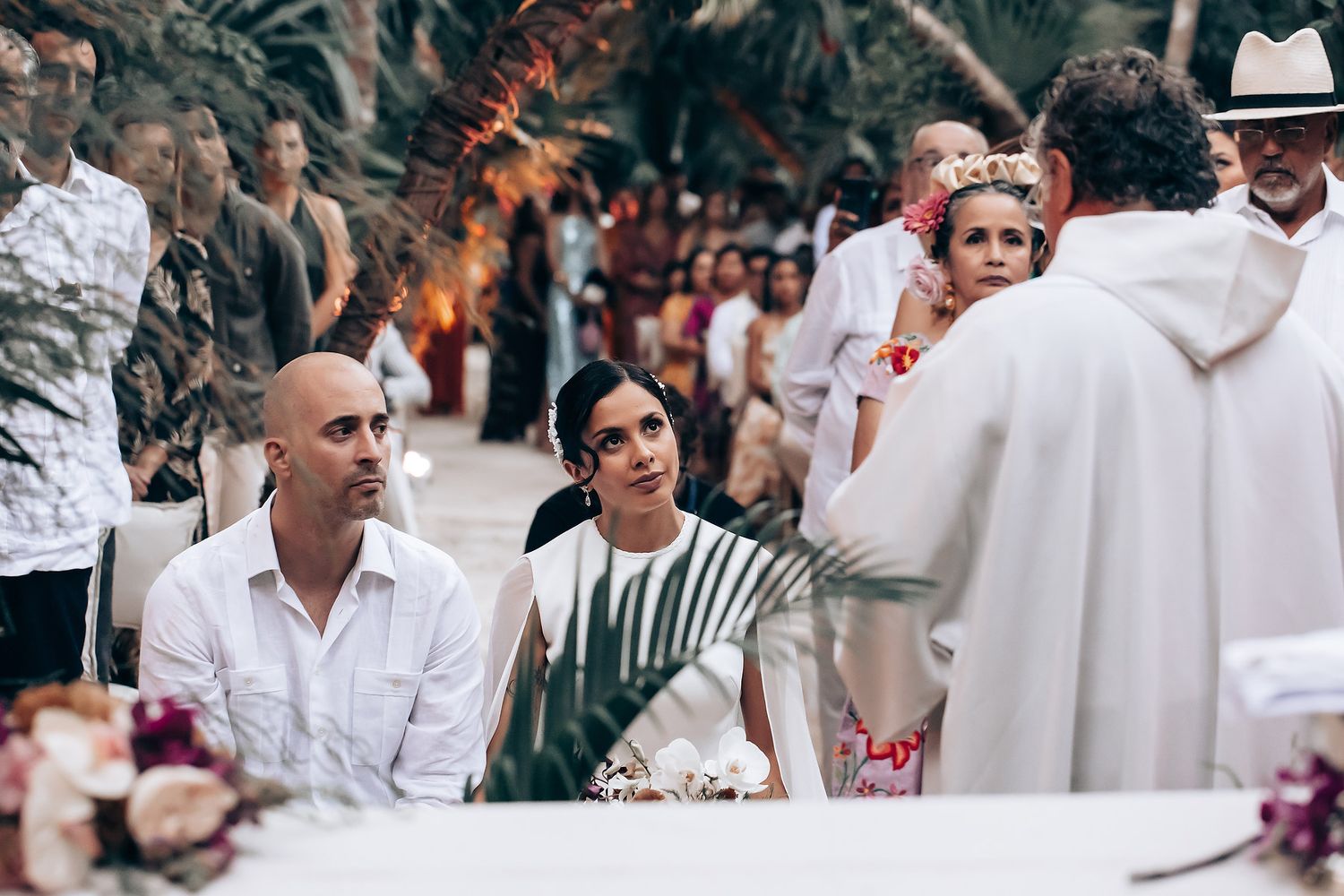 Wedding celebration guests enjoying an outdoor reception under palm trees.