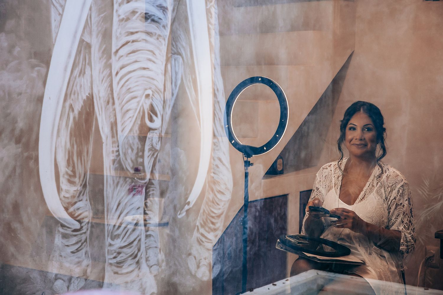 Multiple white wedding gowns with detailed embroidery and beading displayed in a soft-lit setting.