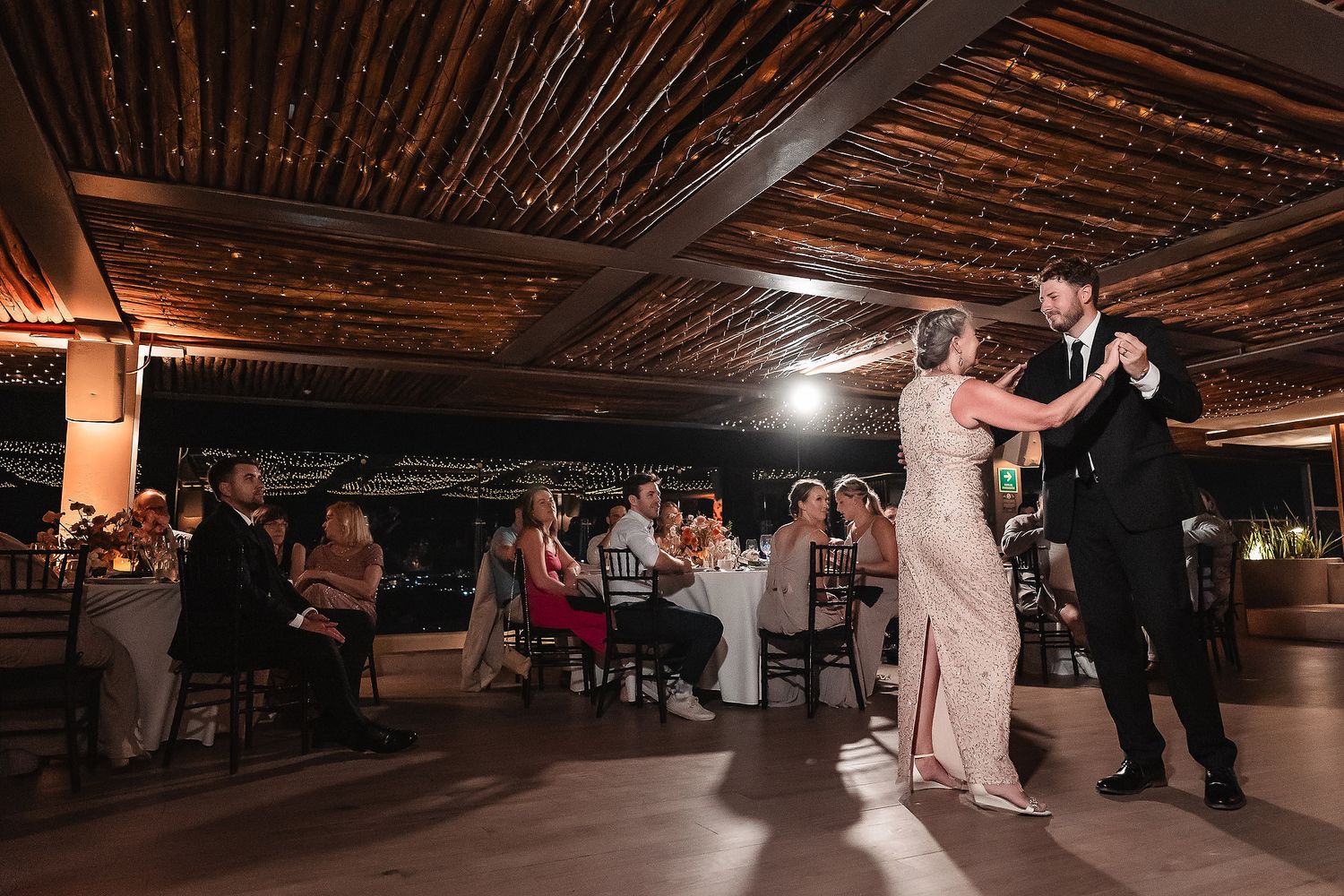 Dance floor at a wedding reception with string lights creating an intimate ambiance.