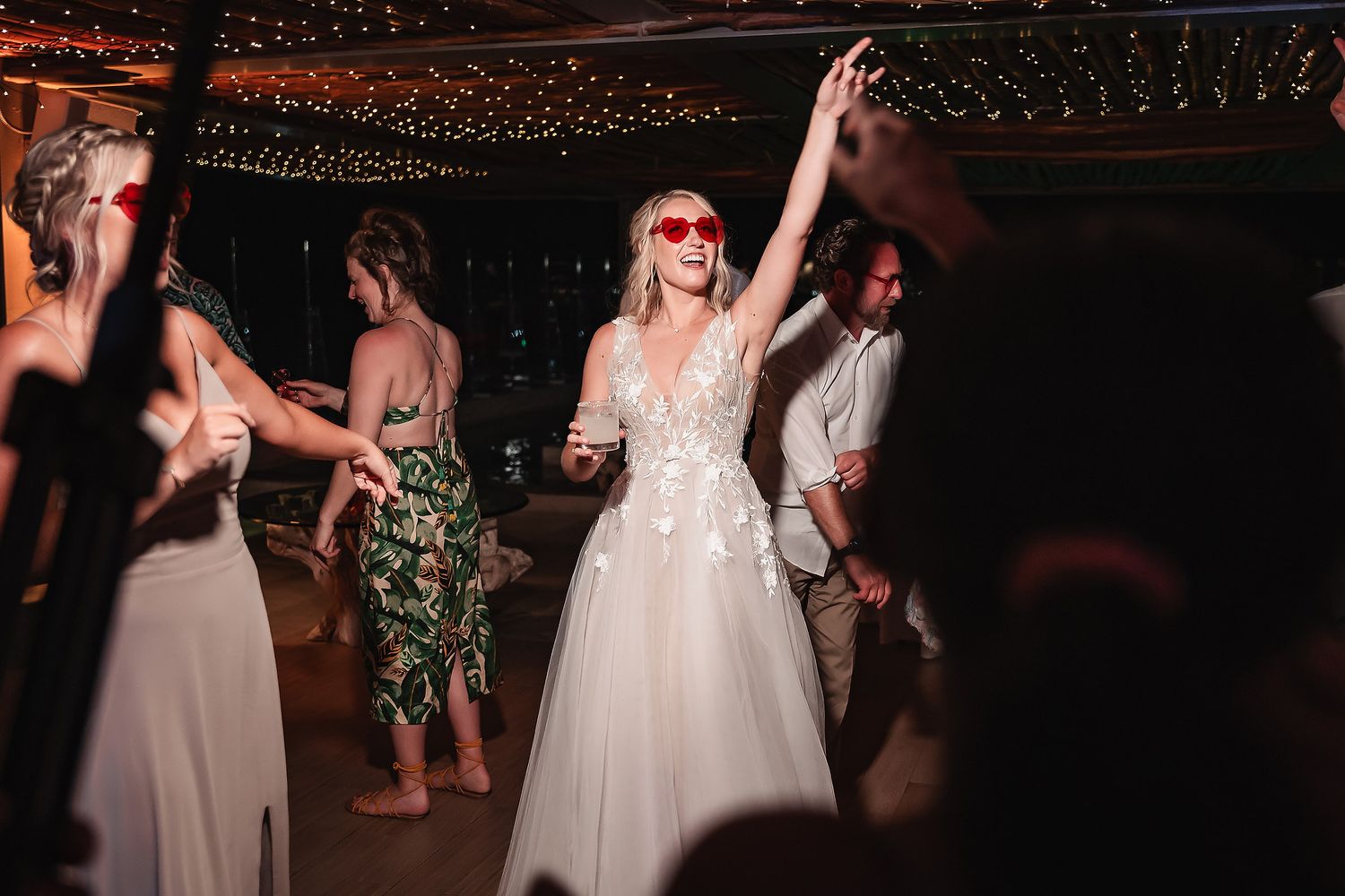 Wedding reception dance party with string lights creating festive atmosphere.