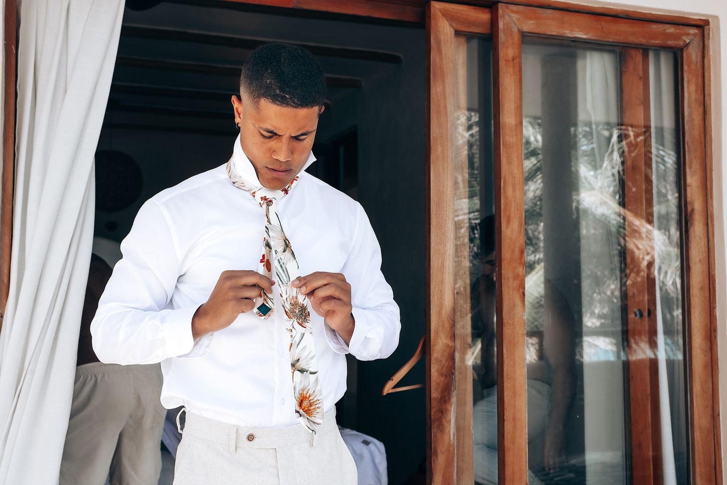 A series of wedding preparation photos showing someone in a white dress shirt getting ready.