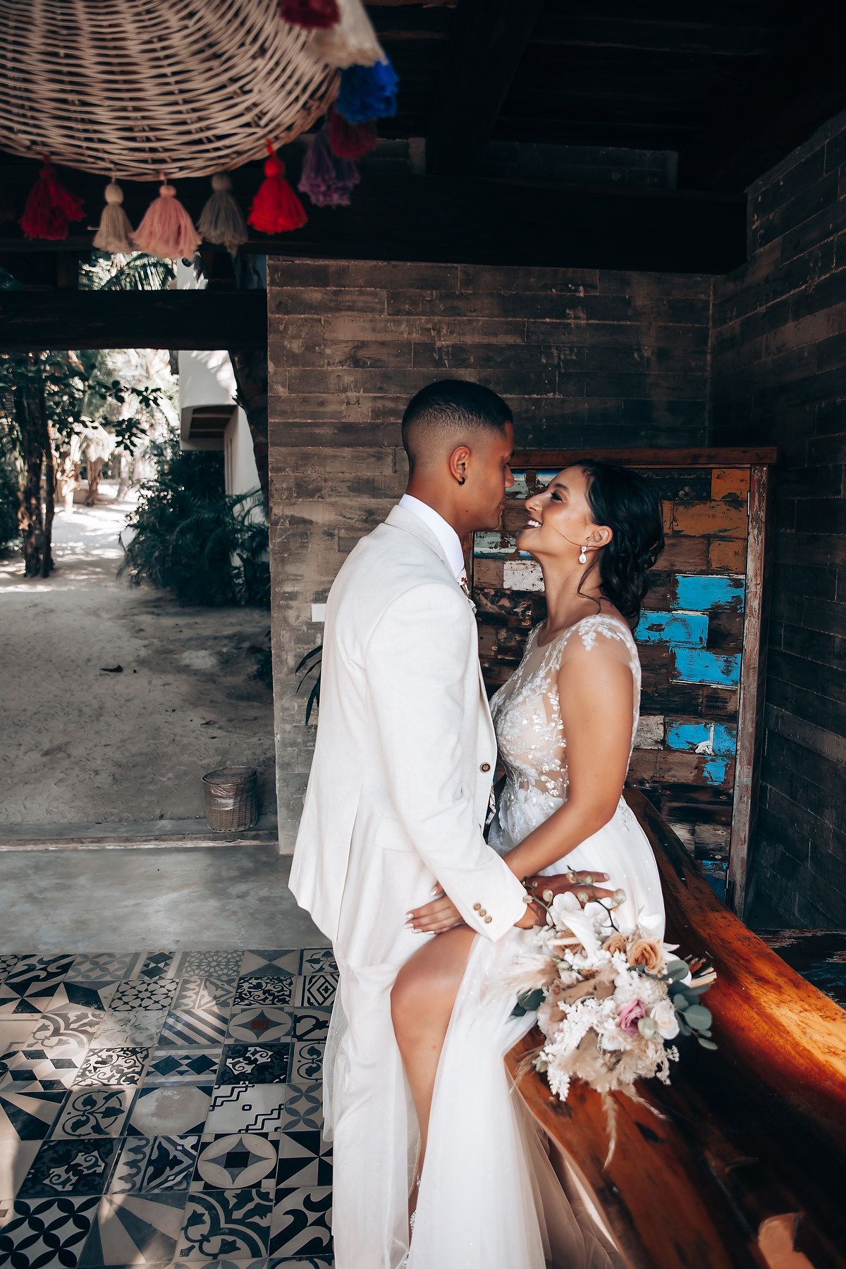 Romantic wedding couple sharing intimate moments in a rustic brick-walled venue.