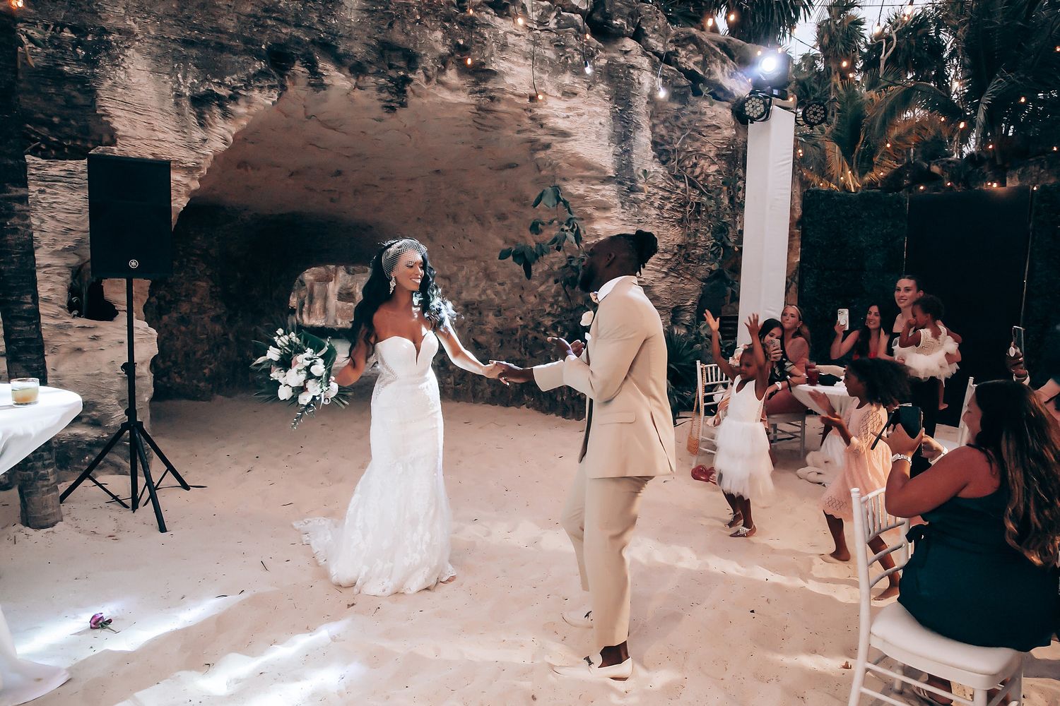 Wedding reception with guests dancing and celebrating in a natural stone venue.