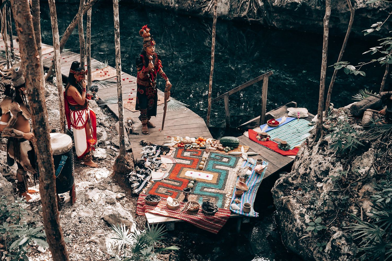 Aerial view of guests celebrating at an outdoor wedding ceremony in a wooded area.