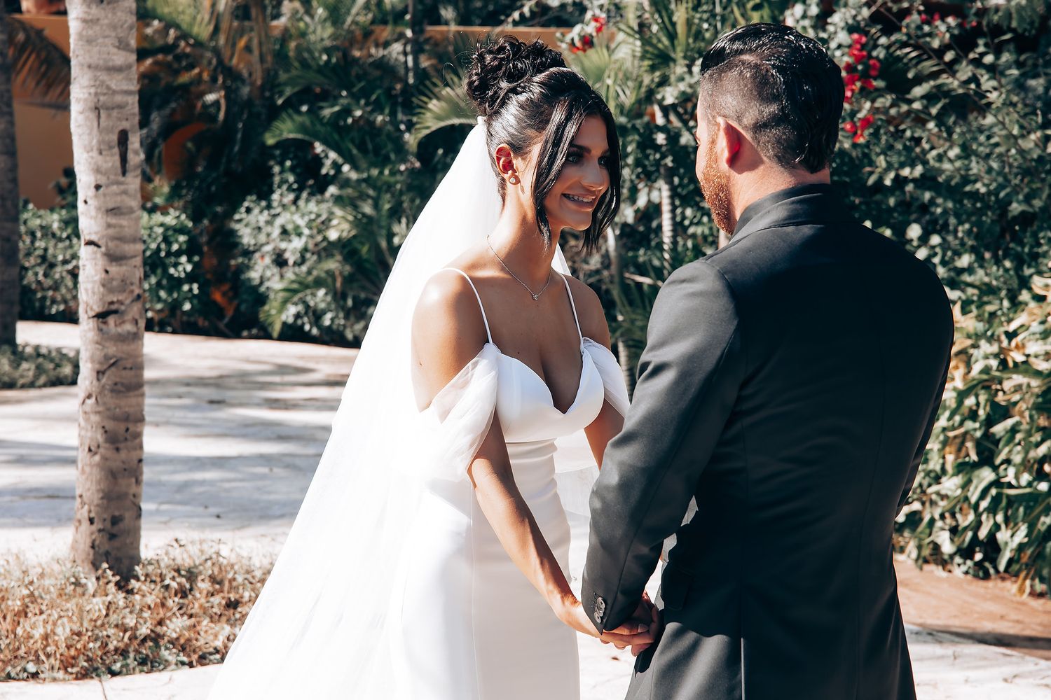 Romantic garden wedding ceremony with palm trees and tropical landscaping.