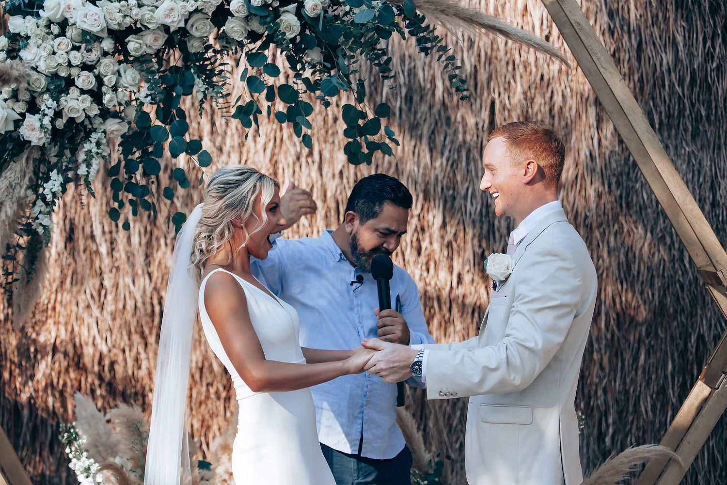 Intimate wedding ceremony moment captured under rustic outdoor decor.