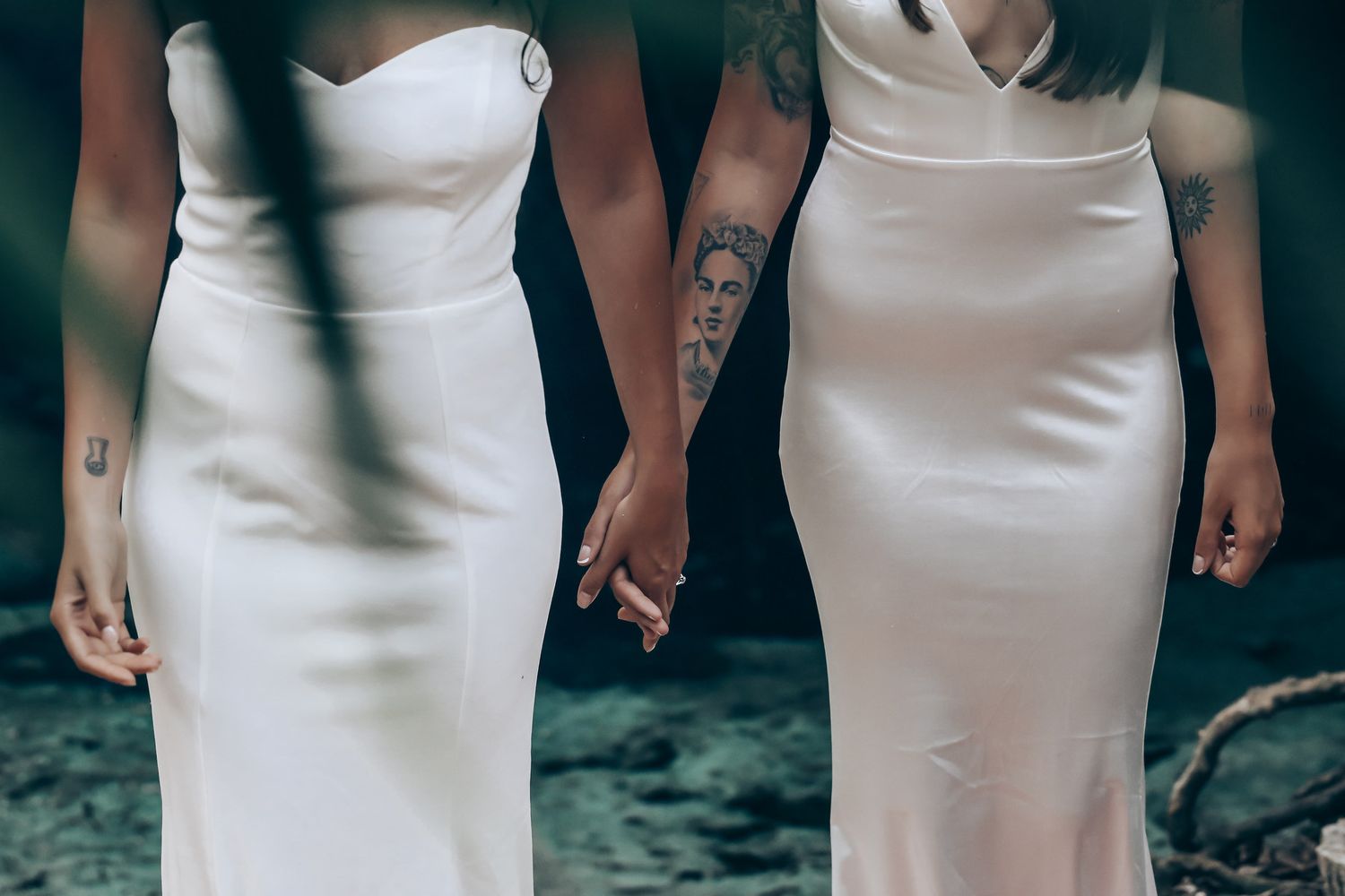 Close-up view of two elegant white wedding dresses showing intricate details and silhouettes.