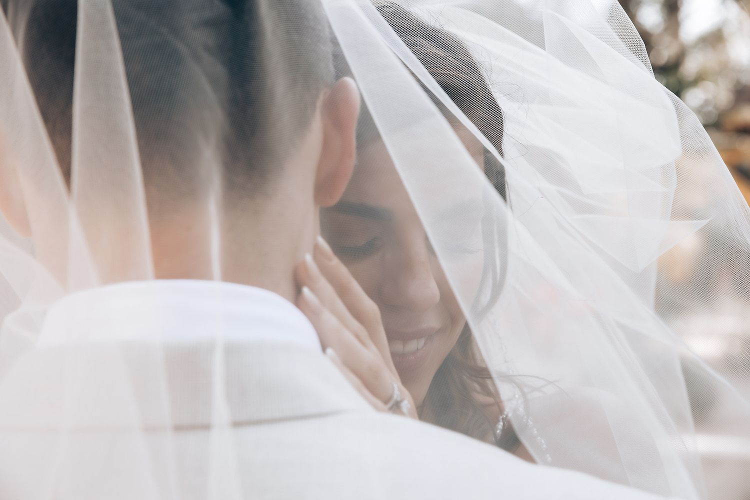 Flowing white wedding veil catching sunlight in tropical setting.