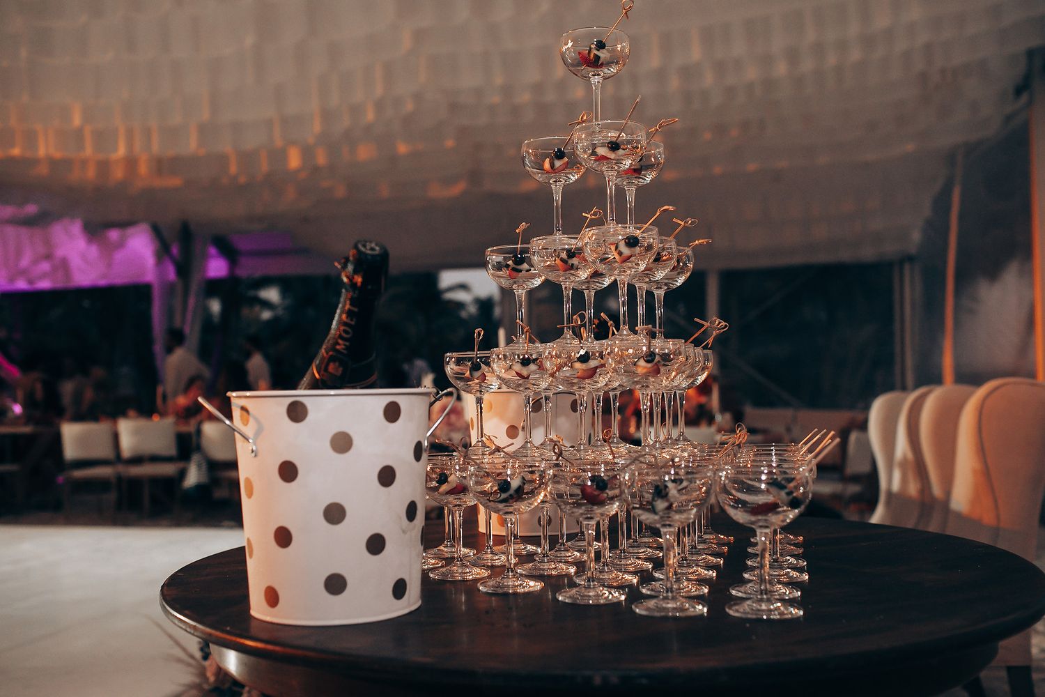 Elegant wedding reception table setup with polka dot details and crystal glassware.