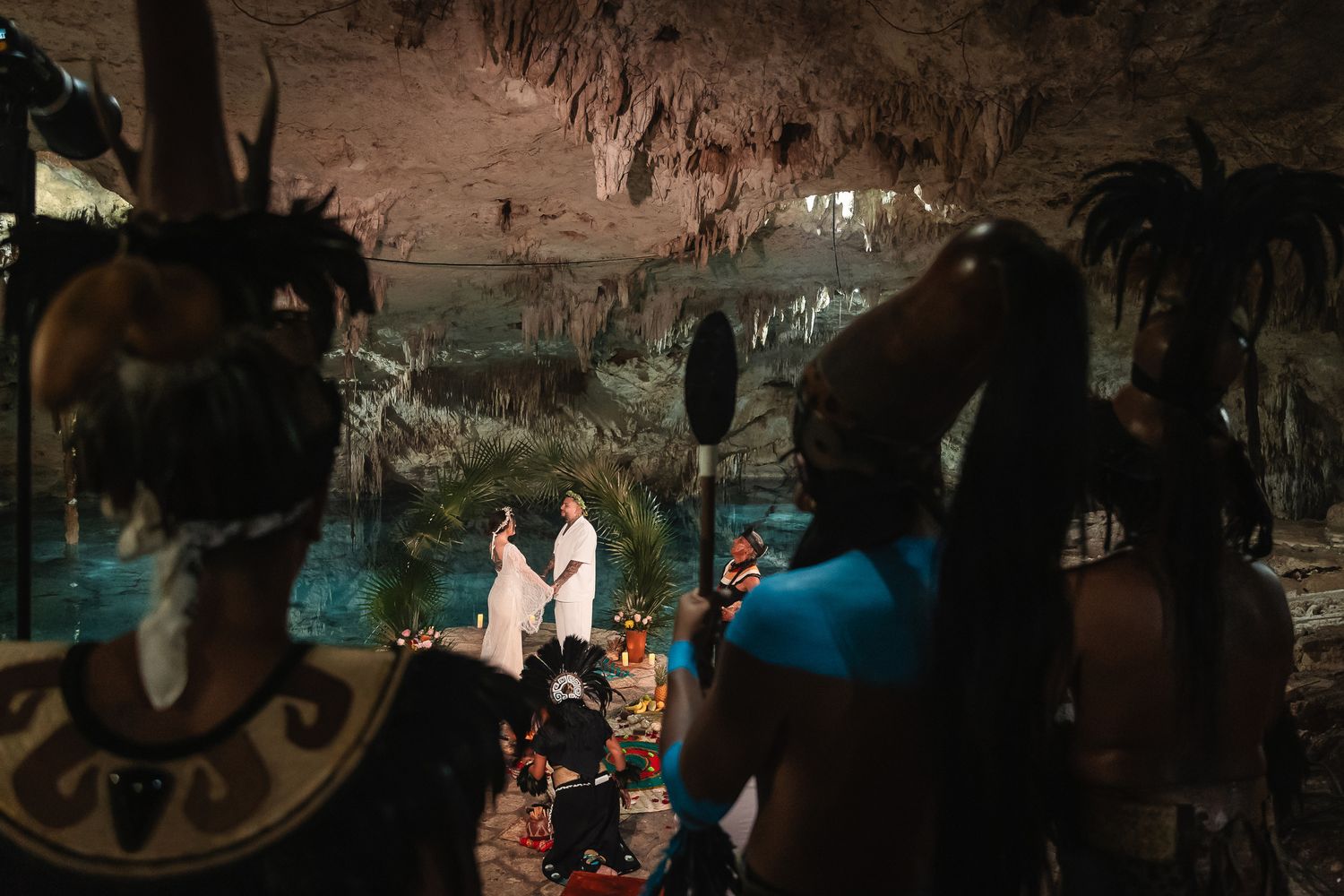 Dark and moody cave wedding reception with dramatic lighting and natural rock formations.