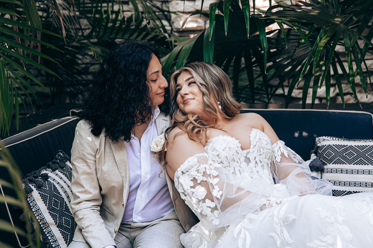 Wedding couple shares intimate moment while seated outdoors during their celebration.